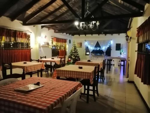 a restaurant with tables and a christmas tree and a piano at Hostería El Tisaleño in Ambato