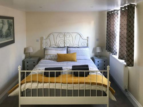 Schlafzimmer mit einem Bett mit blauen und gelben Kissen in der Unterkunft Tiptoe in Steeple Ashton
