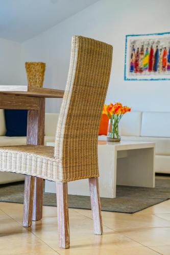 a wicker chair sitting next to a wooden table at Branco Suites - Rooms & Holiday Apartments in Santa Maria