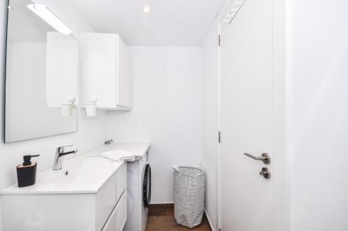 a white bathroom with a sink and a mirror at Acogedora Suite con entrada independiente in Masnou