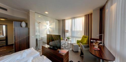 a hotel room with a bed and a desk and a television at Business-Hotel Artes in Chemnitz