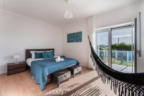 Un dormitorio con una cama y una hamaca. en Beachfront Villa In Esposende, en Esposende
