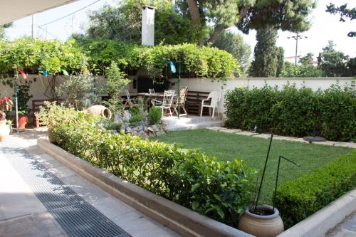 a garden with a table and chairs and plants at Vouliagmeni Riviera Apartments in Athens