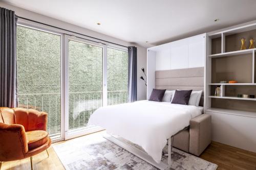 1 dormitorio con cama blanca y ventana grande en Moder en Estambul