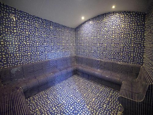 bagno con pareti piastrellate blu e panca di Ramada by Wyndham Istanbul Florya a Istanbul