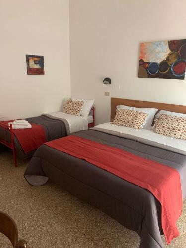 a bedroom with two beds and a painting on the wall at Hotel villa del bagnino in Rimini