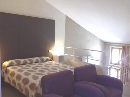 a bedroom with a bed and a chair in it at Apartamentos Bergantes in Ortells