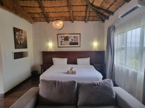 a bedroom with a bed and a couch in it at Qabuleka BnB in Nongoma
