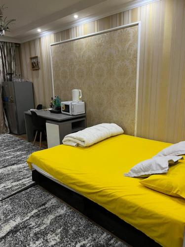 奇西瑙的住宿－Center in the center，一间卧室配有黄色的床和一张书桌