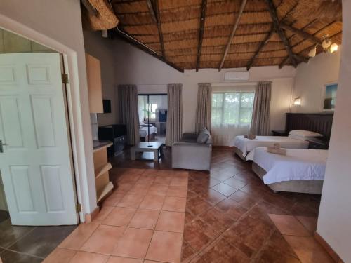 a bedroom with two beds and a living room at Qabuleka BnB in Nongoma