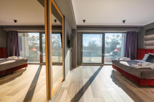 a bedroom with two beds and a large window at Villa Athos in Corfu Town