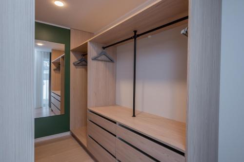 a walk in closet with wooden cabinets and a mirror at Kalda Villa 