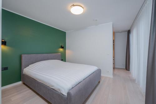 a bedroom with a bed and a green wall at Kalda Villa in Kitseküla