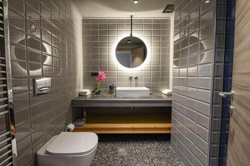 ein Badezimmer mit einem WC, einem Waschbecken und einem Spiegel in der Unterkunft Villa Athos in Gouvia