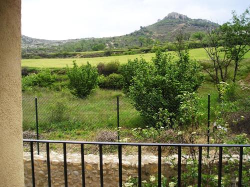 a fence with a field and a mountain in the background at Apartamentos Bergantes in Ortells