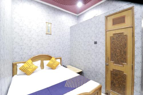 a bedroom with two beds and a wooden door at Hotel Classic in Lucknow