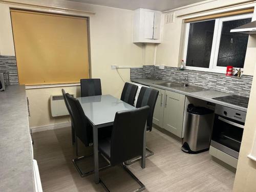 eine Küche mit einem Tisch und Stühlen in der Unterkunft The glorious 3 bedroom apartment with parking in Nottingham