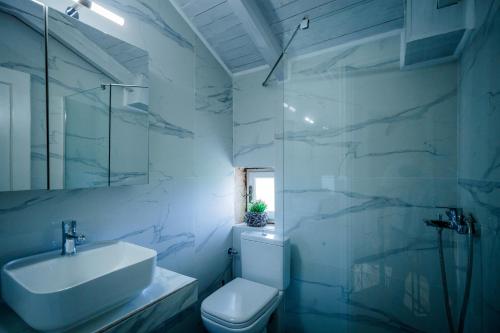 bagno bianco con lavandino e servizi igienici di Sincerity Luxury Villa a Tragaki