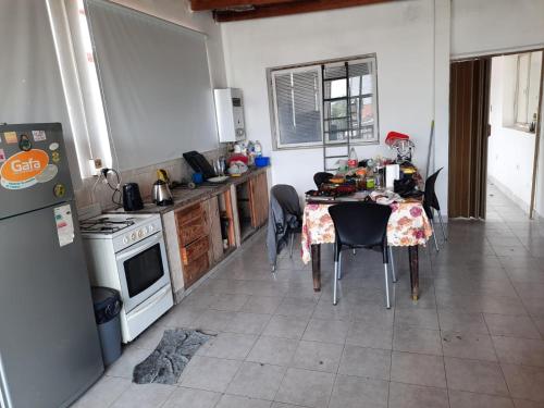 a kitchen with a table with chairs and a refrigerator at Alojamiento Portal Salta in Salta