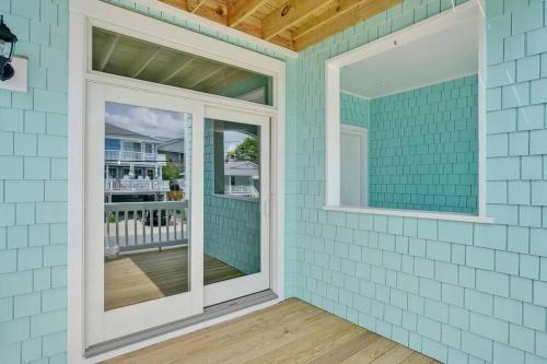 ein blaues Haus mit zwei Fenstern und einem Balkon in der Unterkunft Henderson Haven 4 BR / 3 BA Villa, Steps to Beach in Wrightsville Beach
