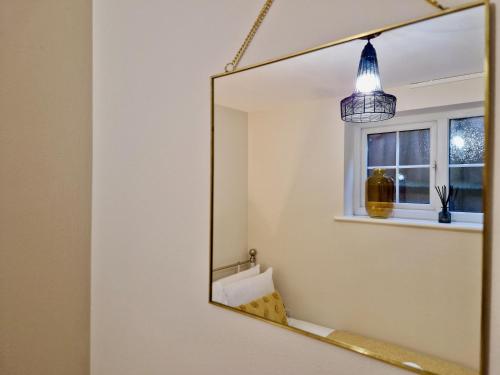 ein Bad mit einem Spiegel und einem Fenster in der Unterkunft Stylish Luxury Serviced Apartment next to City Centre with Free Parking - Contractors & Relocators in Coventry