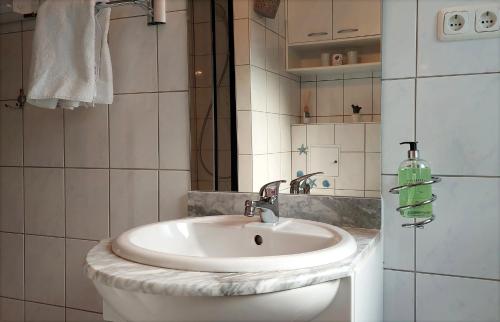 W łazience znajduje się biała umywalka i prysznic. w obiekcie Bungalowpark Zinglingsberg by Rujana w mieście Binz