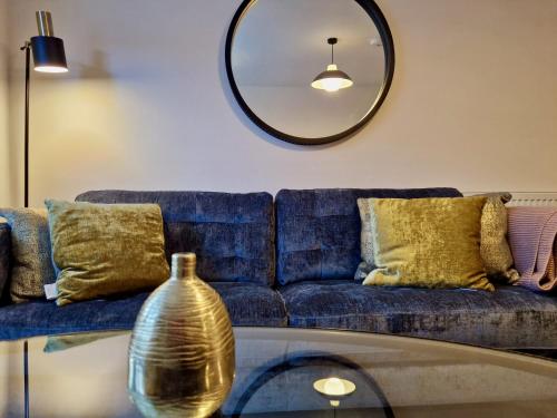 a living room with a blue couch and a mirror at Stylish Luxury Serviced Apartment next to City Centre with Free Parking - Contractors & Relocators in Coventry