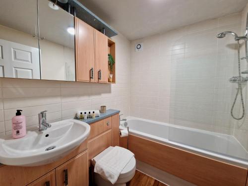 a bathroom with a sink and a toilet and a tub at Stylish Luxury Serviced Apartment next to City Centre with Free Parking - Contractors & Relocators in Coventry