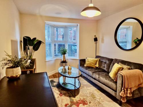 ein Wohnzimmer mit einem Sofa und einem Tisch in der Unterkunft Stylish Luxury Serviced Apartment next to City Centre with Free Parking - Contractors & Relocators in Coventry