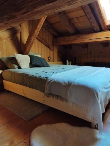 une chambre avec un grand lit dans un grenier dans l'établissement Joli cocon au pied des montagnes, à La Côte-dʼAime
