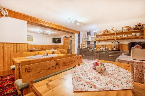uma cozinha com mobiliário em madeira, uma mesa e um lavatório em Penzión Ciriak em Ždiar