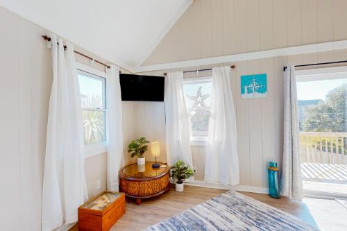 a bedroom with a table and two windows at Knot a Care in Buxton