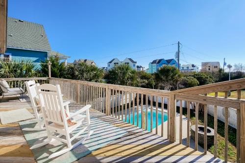 a deck with two chairs and a swimming pool at Knot a Care in Buxton