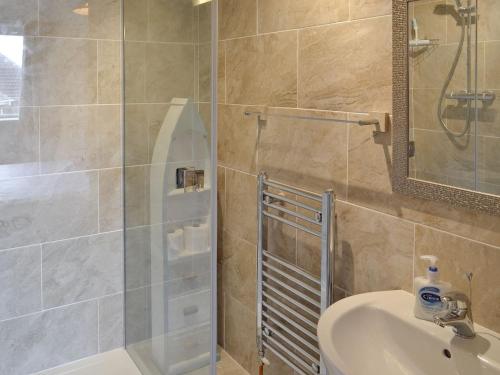 a bathroom with a shower and a sink and a mirror at Bayview in Overcombe
