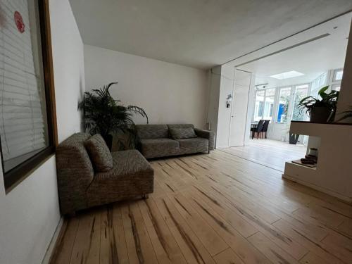 salon z 2 kanapami i drewnianą podłogą w obiekcie New 5min TU Delft & city center Garden Room Cleo w mieście Delft