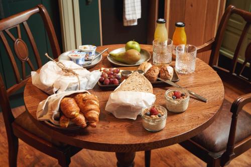 a wooden table with food and bread and fruit on it at The Masons Arms in Branscombe