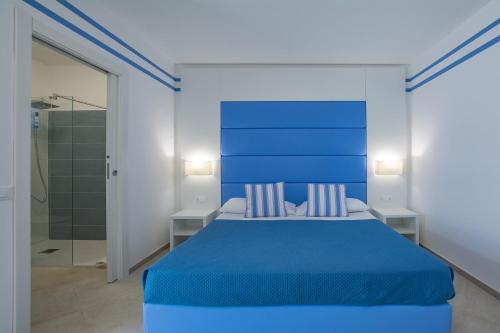 a blue bedroom with a blue bed and a shower at Brezza Marina in Lampedusa