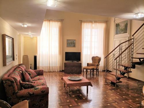 een woonkamer met een bank en een tv bij Casa Alexandra in centro e a pochi passi dal mare in Imperia