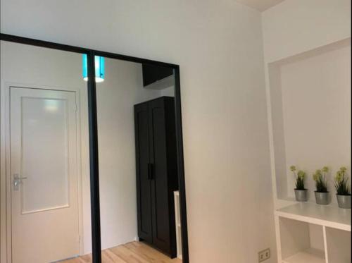 um quarto com um espelho e uma porta com plantas em New 5min TU Delft & city center Garden Room Cleo em Delft