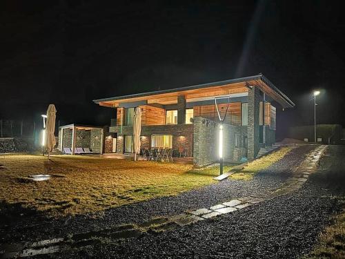 Una casa se ilumina por la noche en VILA ESCAPE - Pe Malul Lacului Firiza,Maramures, en Baia Mare