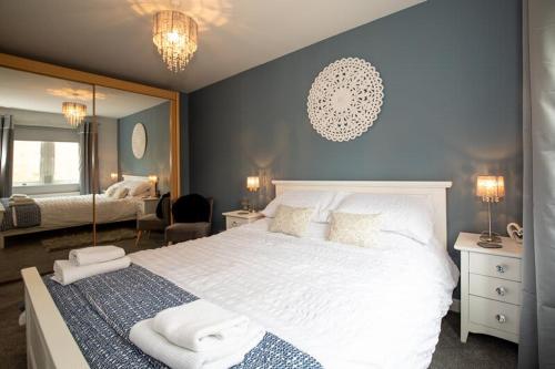 um quarto com uma grande cama branca e uma parede azul em Host & Stay - Blue Bridge View em York