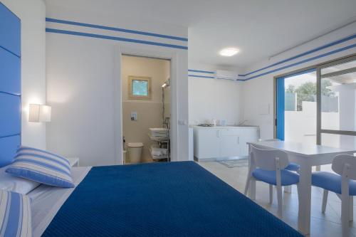 a blue and white bedroom with a table and a bed at Brezza Marina in Lampedusa