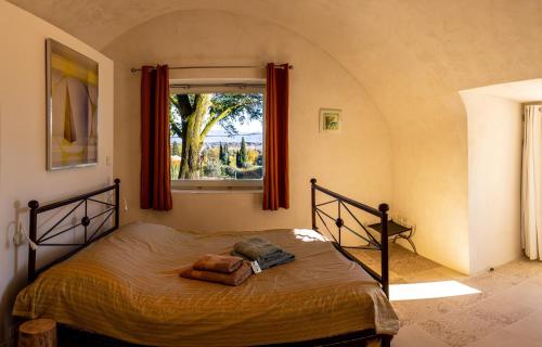 une chambre avec un grand lit avec une fenêtre dans l'établissement Havre de paix à Chamaret - Gite de charme en Drôme Provençale, à Chamaret