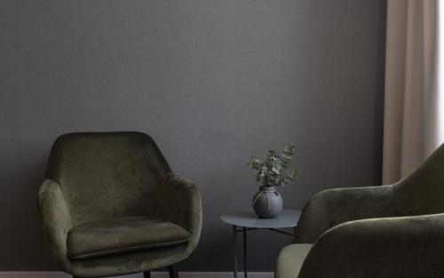 a living room with a chair and a vase of flowers at Hotel Victoria in Skellefteå
