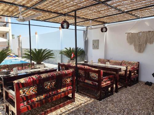 un restaurante con sillas, una mesa y una piscina en CASA LOKO Guest House, en Luxor