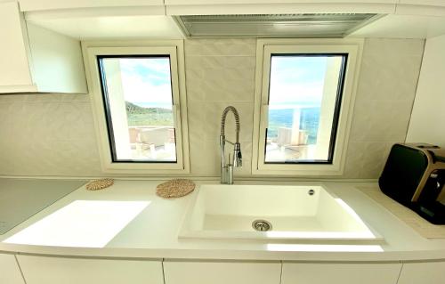 a white sink in a kitchen with two windows at Villa Olimpo in Avola