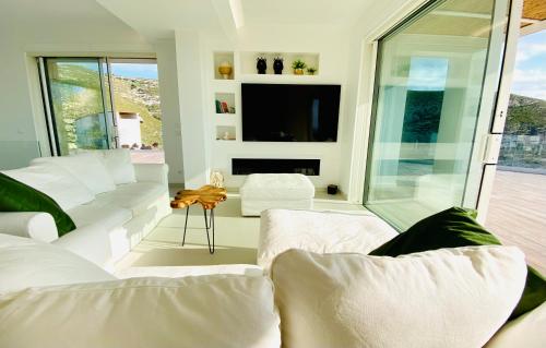 uma sala de estar com sofás brancos e uma televisão em Villa Olimpo em Avola