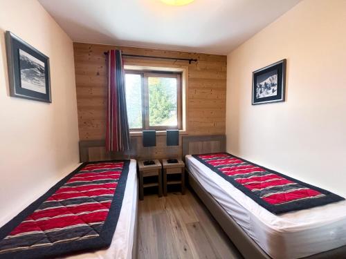 une chambre avec deux lits et une fenêtre dans l'établissement Chalet Emeraude - 10 personnes - Plagne Soleil, à Plagne Villages