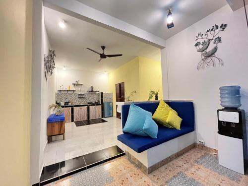 a living room with a blue couch and a kitchen at Villa Cinta Family in Gili Trawangan