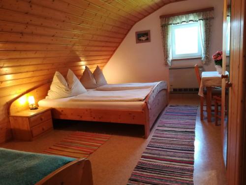 a bedroom with a bed in a wooden room at Familienbauernhof Imitz, Ferienwohnung in Spital am Pyhrn